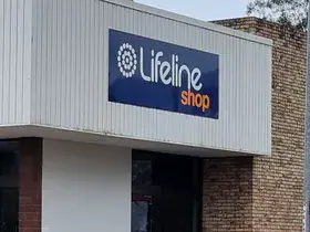The Lifeline Dapto Shop seen from the street, a two-storey brick corner building with a Lifeline Shop sign on each street frontage